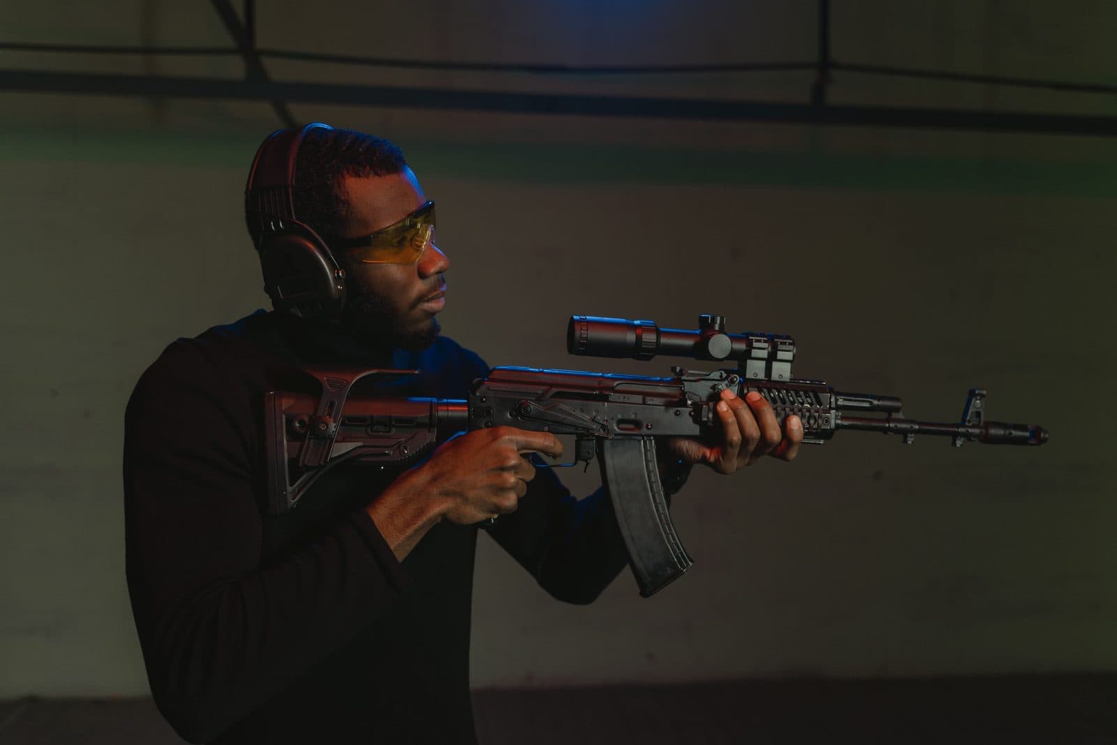 Handguns and a rifle on a range bench, looking downrange